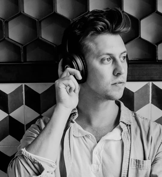 Man wearing headphones pensively looking to the left.